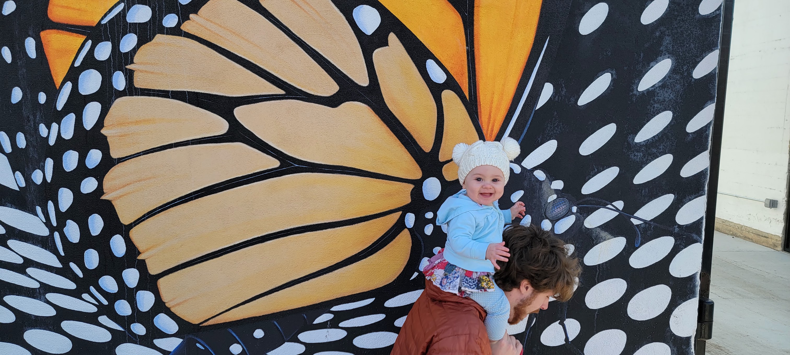 Lily in front of the Monarch Mural in Ogden